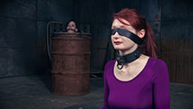 Freya French in metal drum behind collar, blindfolded Violet